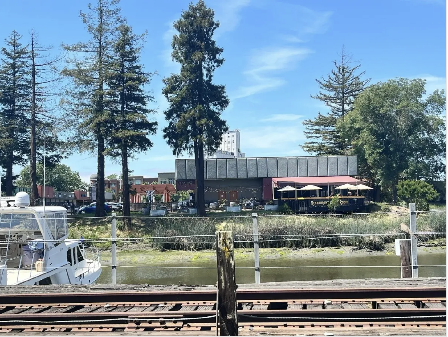 Screenshot of the lead image for the Petaluma Patch article. Picture is of the trestle in the foreground and Taps in the background with a boat tied up to the dock on the far left.